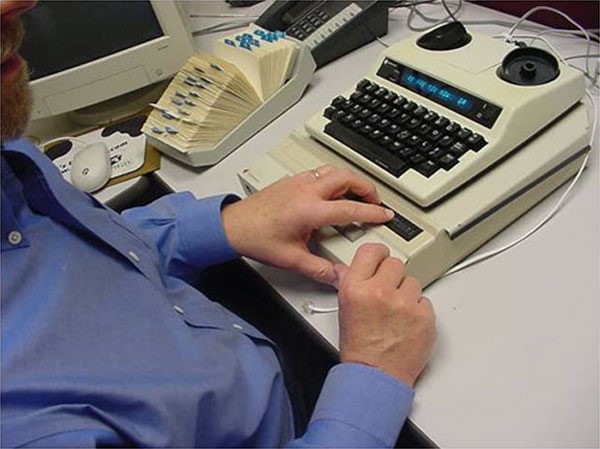 Kurčneregys skambina naudodamasis tekstofonu su Brailio eilute